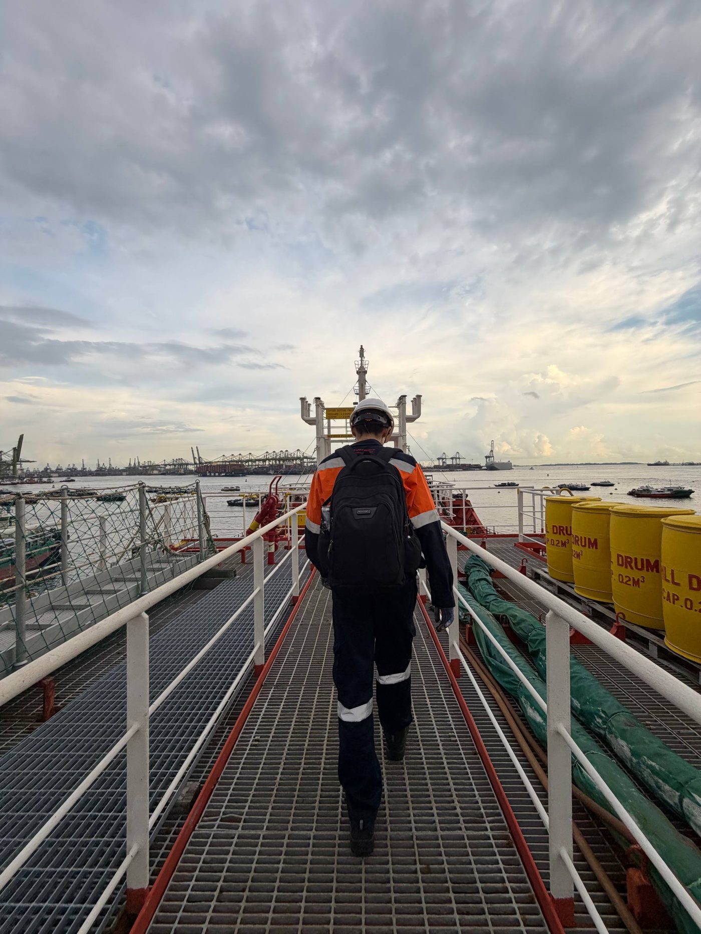 YMA technician heading to a vessel for a job, Singapore port in the background